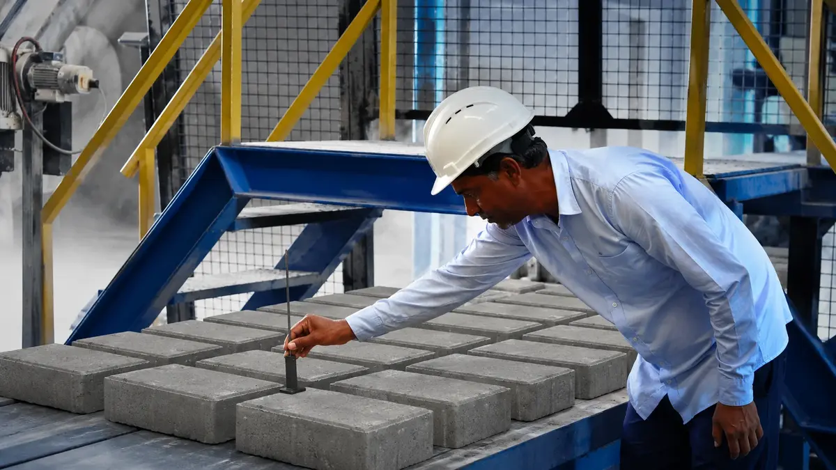 Engenheiro inspecionando blocos de concreto na fábrica Tecnoblocos